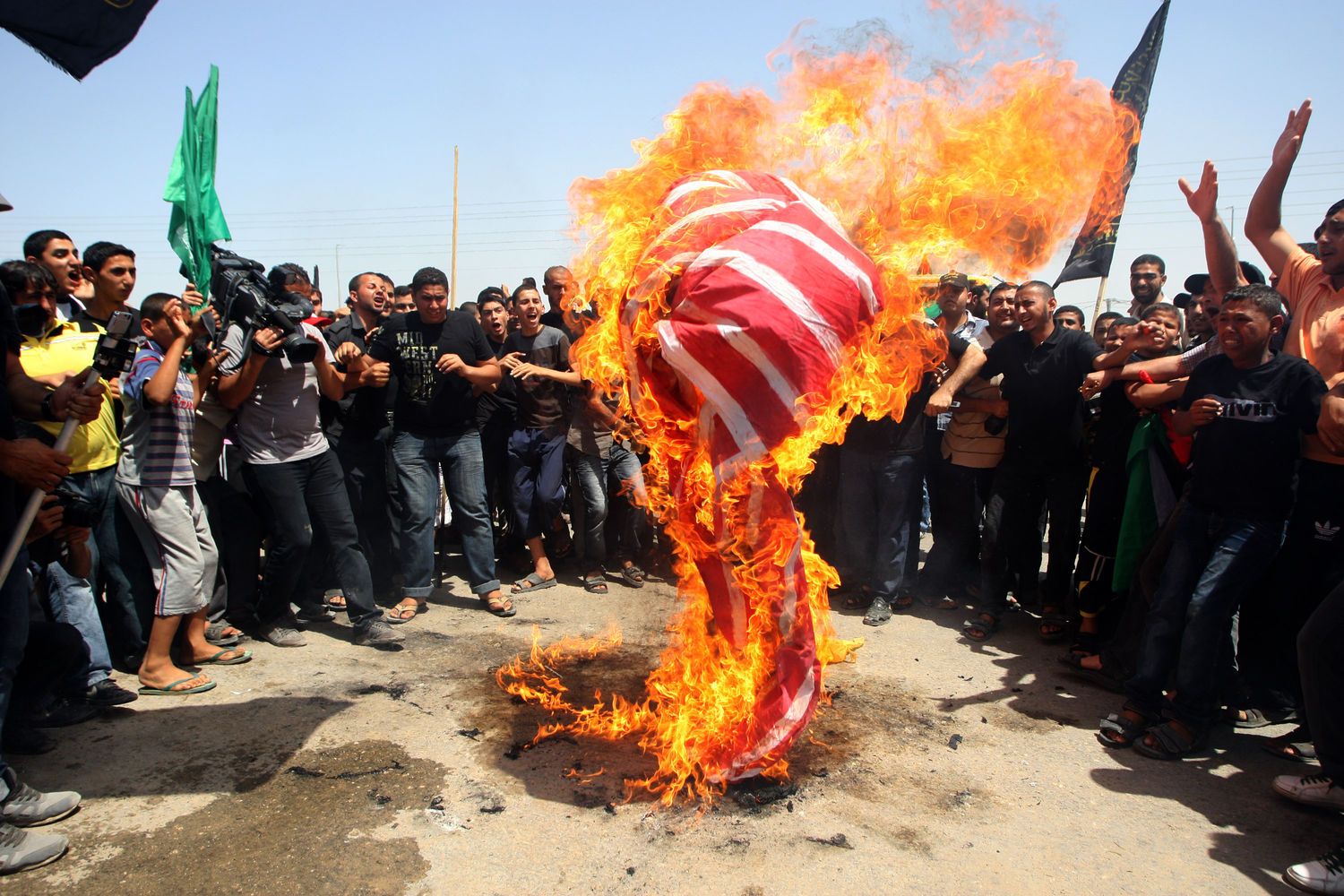 Palestinians burn an American flag