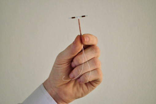 Holding an IUD birth control device in fingers
