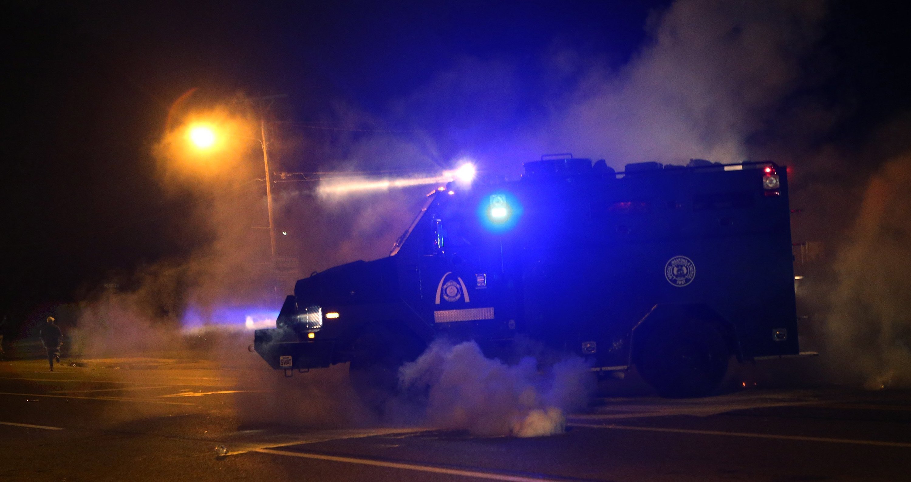 A tactical truck chases protesters down the street, shooting tear gas on W. Florissant Avenue in Ferguson, Mo. on Sunday afternoon, Aug. 17, 2014, after protesters throw rocks and bottles towards the police. (J. B. Forbes/St. Louis Post-Dispatch/MCT)