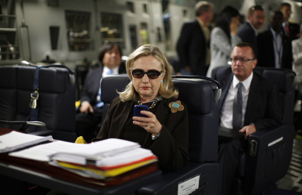 U.S. Secretary of State Hillary Clinton checks her PDA upon departure in a military C-17 plane from Malta bound for Tripoli, Libya October 18, 2011. REUTERS/Kevin Lamarque (UNITED STATES) POOL
