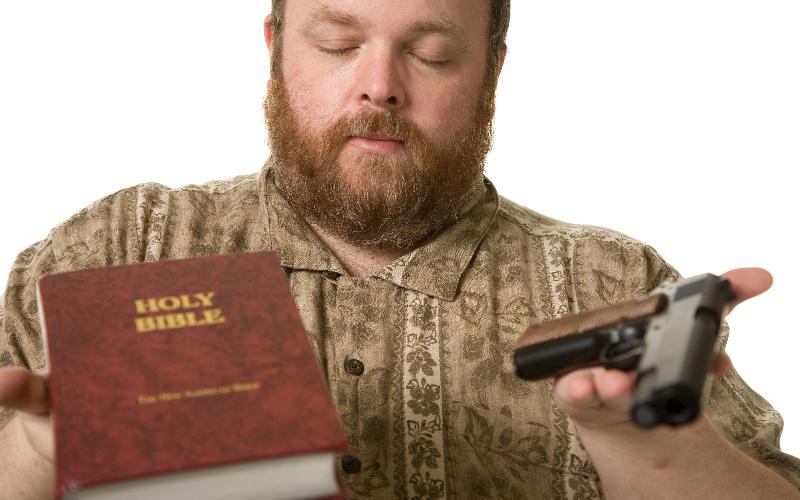 man holding gun and bible