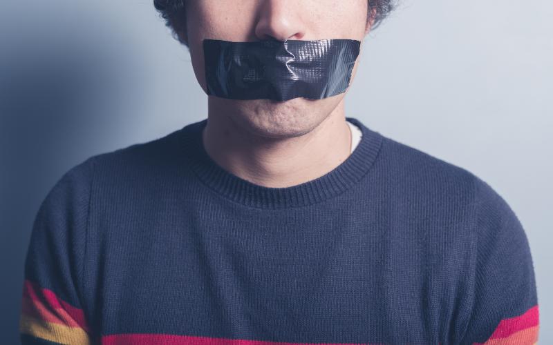 young man with tape over mouth