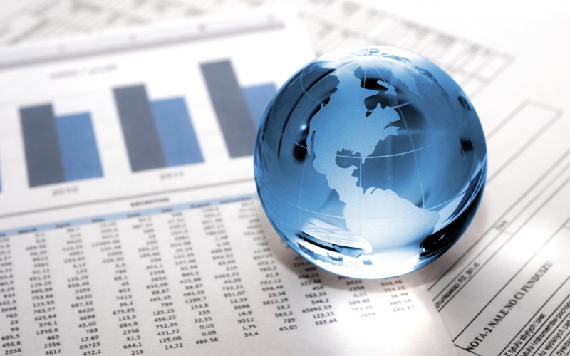 Globe sitting on financial data sheets